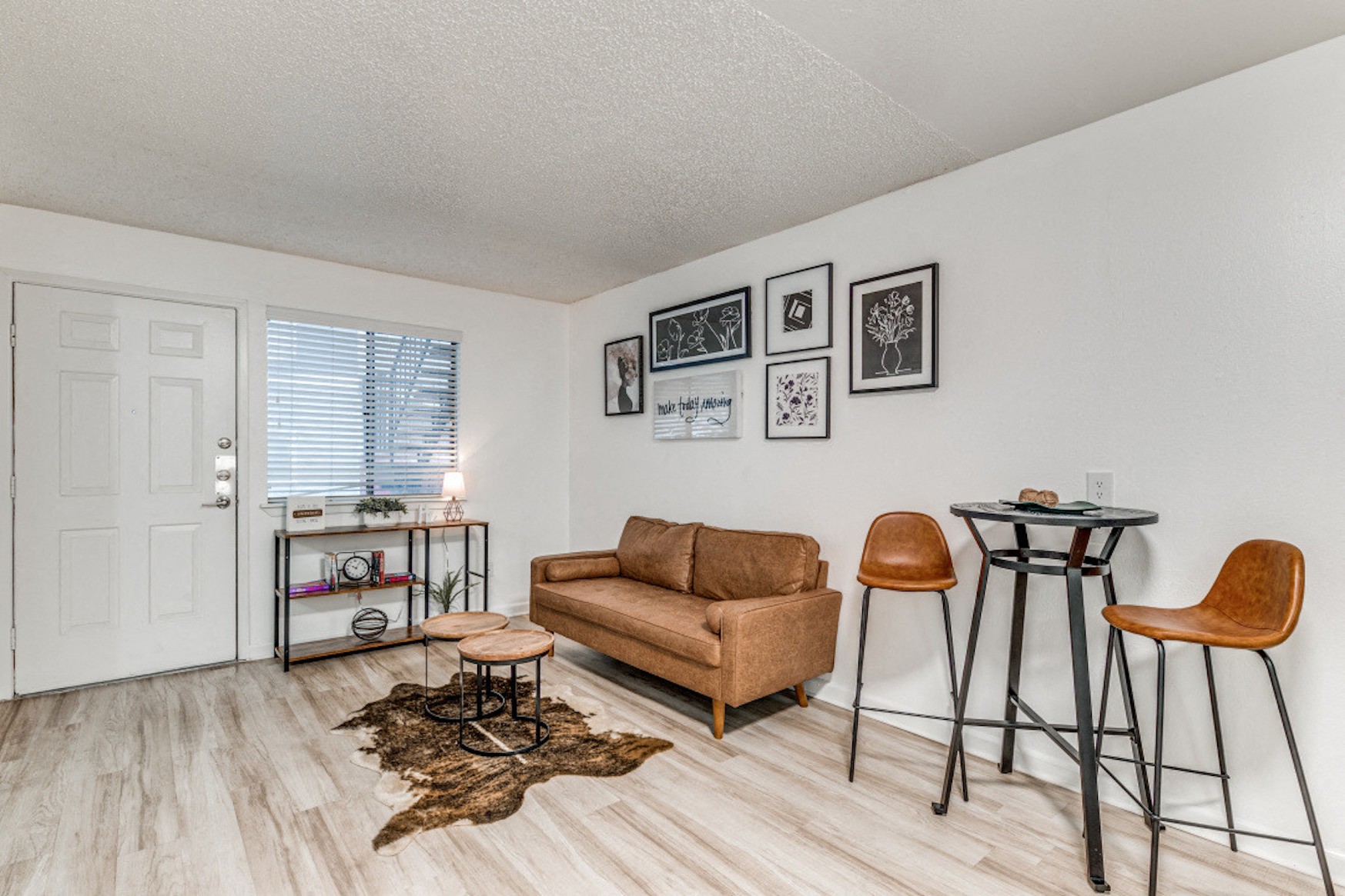 the living room of our two bedroom apartment atrium with a couch and stools